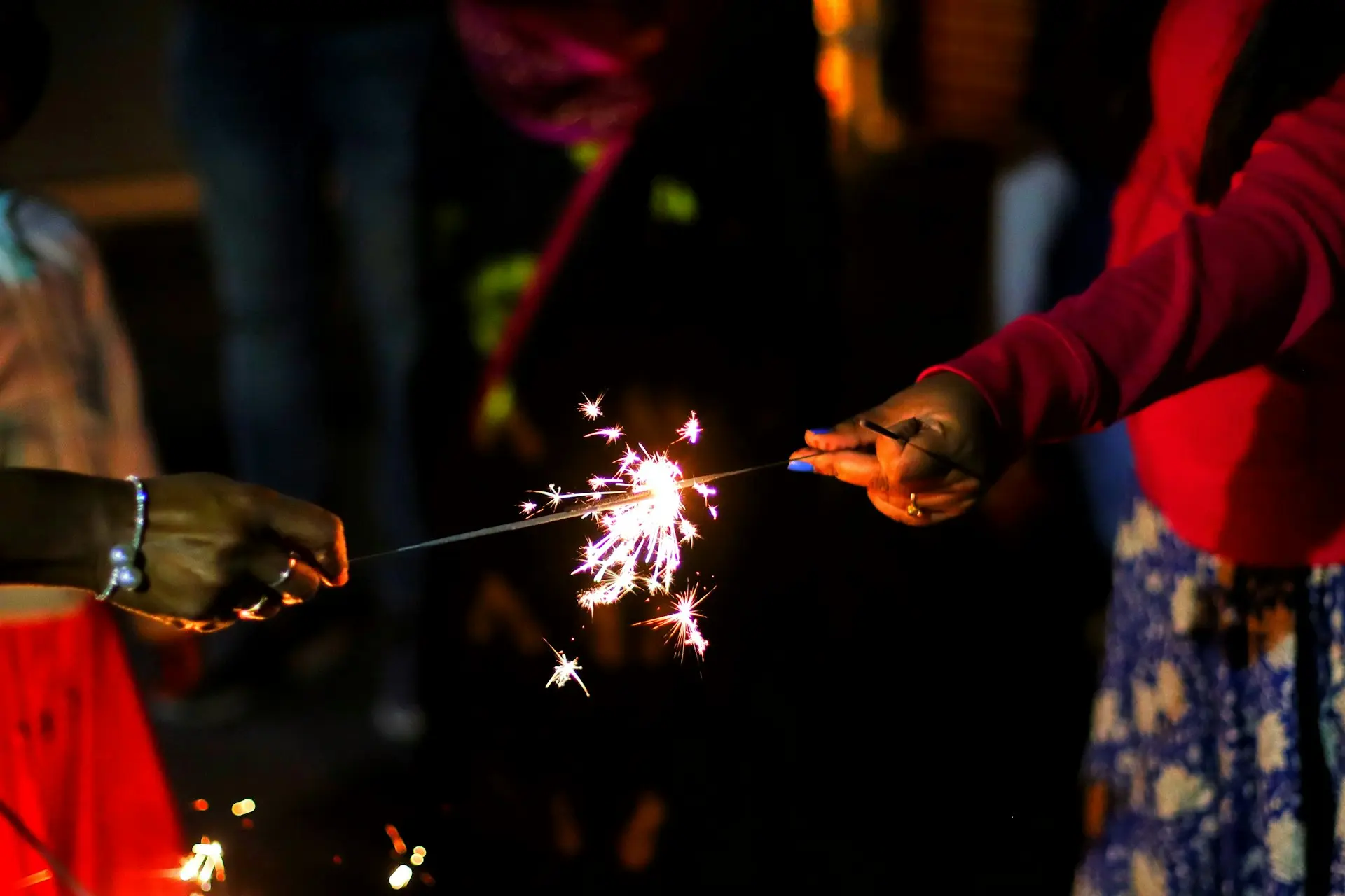two people holding sparklers in their hands